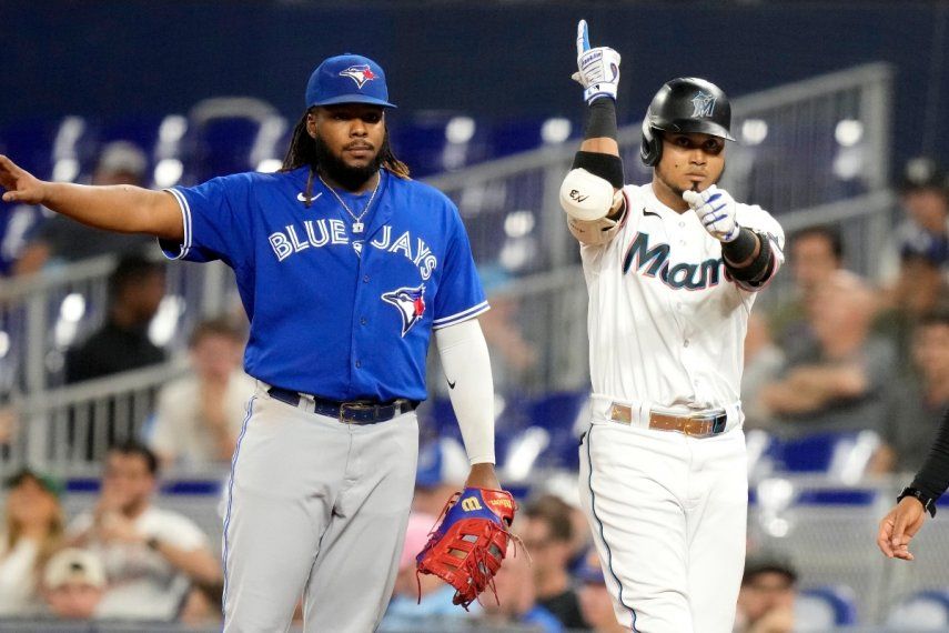 Luis Arráez, derecha, de los Marlins de Miami, reacciona después de batear un sencillo durante la primera entrada del juego de béisbol en contra de los Azulejos de Toronto, el lunes 19 de junio de 2023, en Miami. El primera base de Azulejos, Vladimir Guerrero Jr., izquierda, observa.&nbsp;