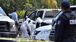 Peritos forenses inspeccionan la zona en la que hubo un enfrentamiento entre bandas rivales en Cancún (México)