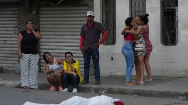 Varias personas lloran junto al cuerpo de un hombre, asesinado en circunstancias desconocidas, en una calle de Durán, Ecuador, el 21 de julio de 2023.