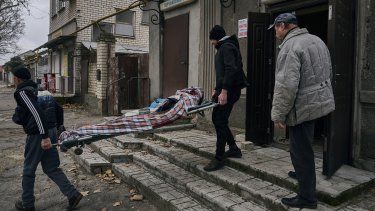 Civiles ucranianos cargan el cuerpo de un hombre de 20 años que murió en un bombardeo ruso en Jersón, Ucrania, el jueves 5 de enero de 2023.&nbsp;