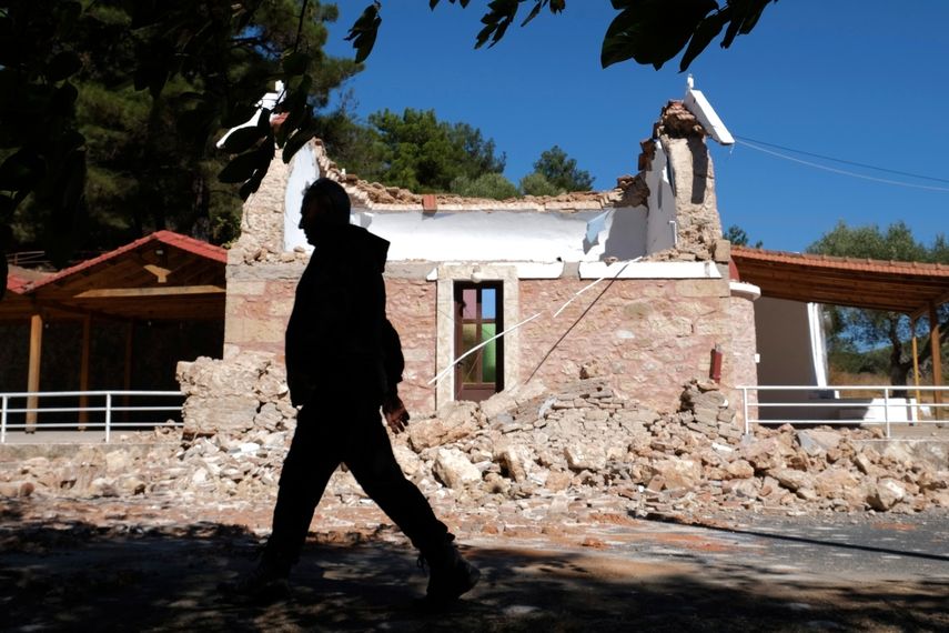 Un vecino pasa junto a una capilla ortodoxa griega dañada por un fuerte sismo en el poblado de Arcalochori, en la isla sureña de Creta, Grecia, el lunes 27 de septiembre de 2021