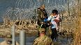 Un inmigrante ingresa por la frontera a Estados Unidos en Eagle Pass, Texas, acompañado de dos menores.&nbsp;