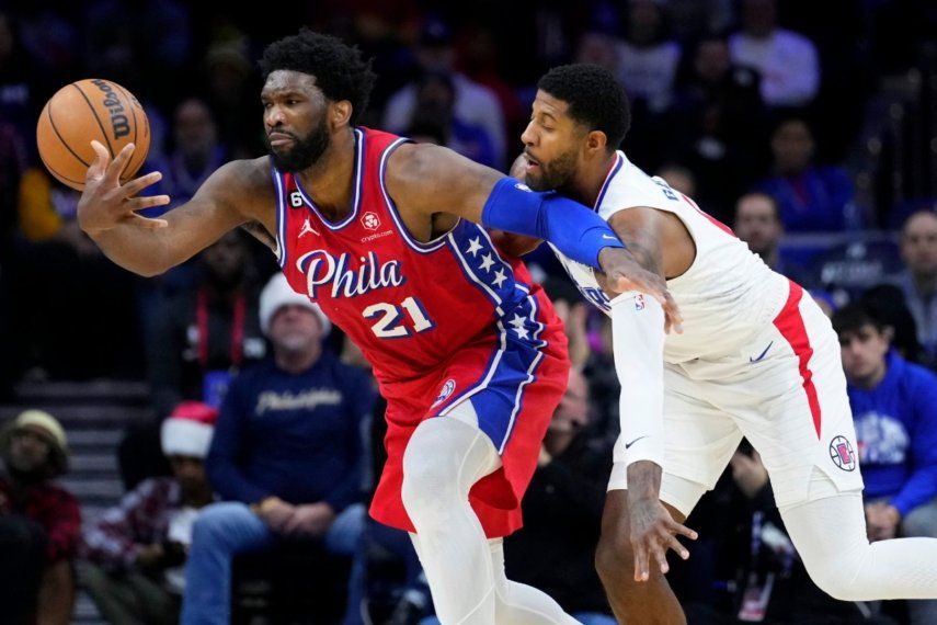 Joel Embiid, de los 76ers de Filadelfia, a la izquierda, intenta aferrarse al balón contra Paul George de Los Angeles Clippers durante la primera mitad de un partido de baloncesto de la NBA, el viernes 23 de diciembre de 2022, en Filadelfia. Paul George regresará a la Conferencia Este, y seguramente ha hecho a Joel Embiid muy feliz en el proceso. George firmará un contrato de cuatro años y 212 millones de dólares con los Philadelphia 76ers, dijo una persona con conocimiento de la medida a The Associated Press el lunes 1 de julio de 2024.&nbsp;