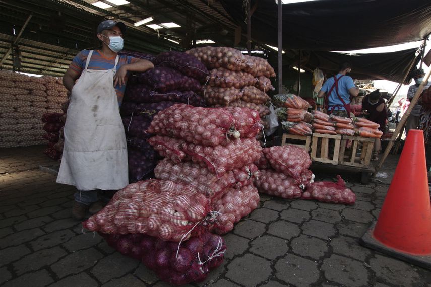 En esta foto del martes 16 de junio en la capital de El Salvador, un vendedor de verduras espera a los clientes en el mercado de La Tiendona d&iacute;as despu&eacute;s de una reapertura luego de tres meses de confinamiento para contener la propagaci&oacute;n del coronavirus.