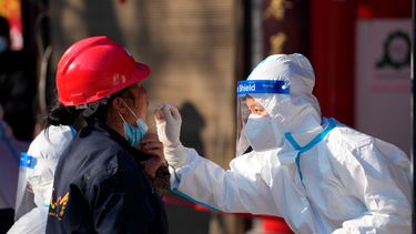 Trabajador toma una muestra en un sitio de pruebas de coronavirus, en Xian, en China, el martes 21 de diciembre de 2021.