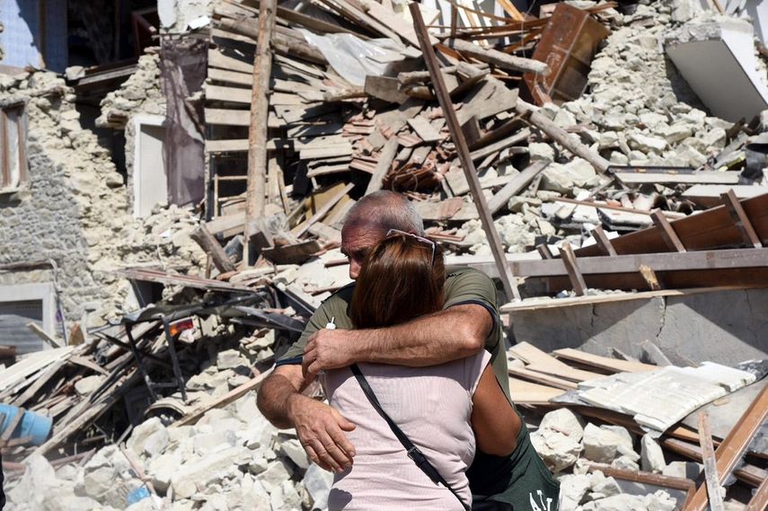Dos lugareños se abrazan ante varias casas derrumbadas en Pescara del Tronto, cerca de la localidad de Arquata del Tronto, en la provincia de Ascoli Piceno, región de Marche, en el centro de&nbsp;Italia, tras el terremoto de este 24 de agosto de 2016.