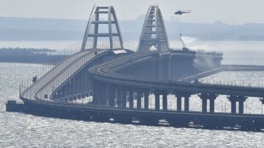 Un helicóptero arroja agua sobre un puente para sofocar un incendio, en el puente que conecta la península de Crimea con el territorio continental ruso sobre el estrecho de Kerch, en Kerch, el 8 de octubre de 2022.&nbsp; 
