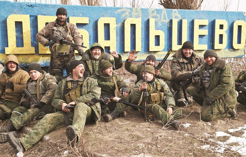 Separatistas prorrusos posaban este viernes pasado frente al cartel de entrada a la ciudad de Debaltseve, Ucrania, festejando la retirada de las tropas oficiales derrotadas por ellos tras semanas de combates. (AP)