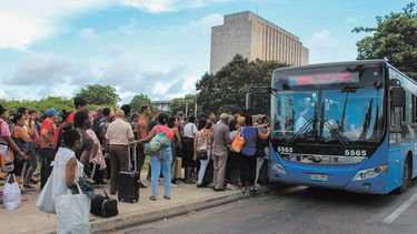 Habaneros se aprestan a subir a un autob&uacute;s en una calle de La Habana.