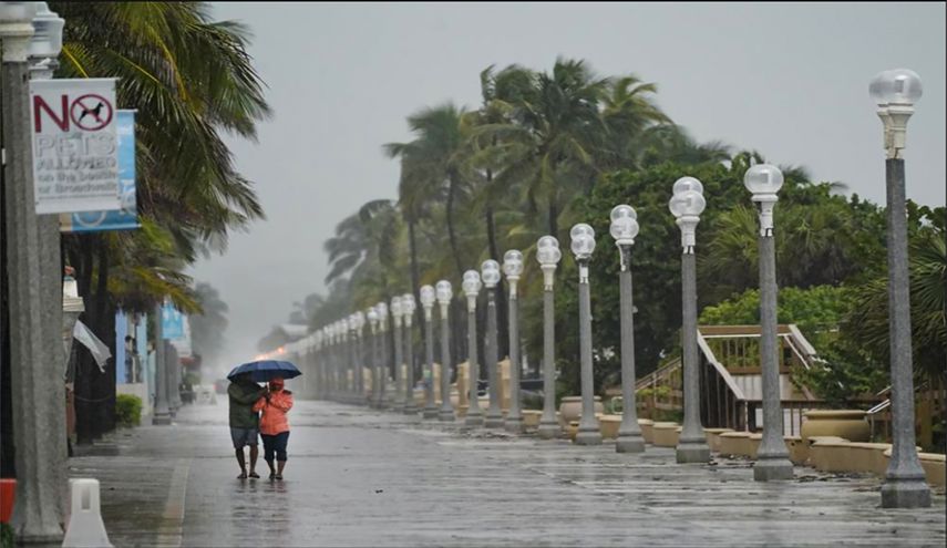 Una paraeja camina por Hollywood Beach Broadwalk, en Florida.