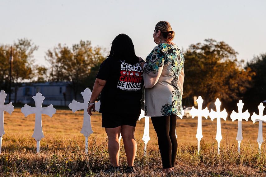 Dos mujeres observan las 26 cruces instaladas en honor de las 26 personas que fallecieron luego del tiroteo en una iglesia Baptista de Sutherland Springs (Texas, EE.UU.), mientras las autoridades continúan trabajando en la escena.&nbsp;&nbsp;