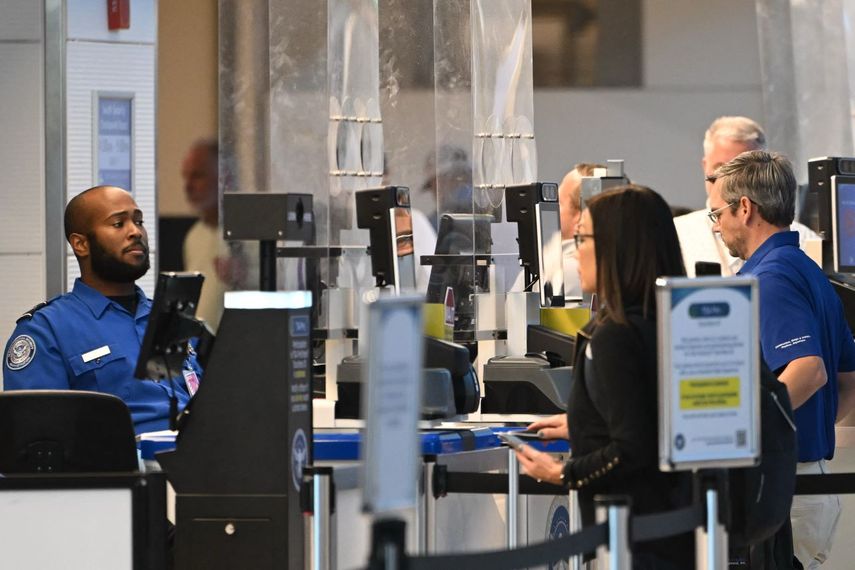 Oficial de la TSA verificando los documentos de identidad de los pasajeros en un punto de control de seguridad en el Aeropuerto Nacional Ronald Reagan, en Arlington, Virginia.