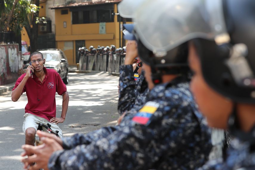 Efectivos policiales bloquean la vía por la cual pasaría una marcha de trabajadores públicos en Caracas.