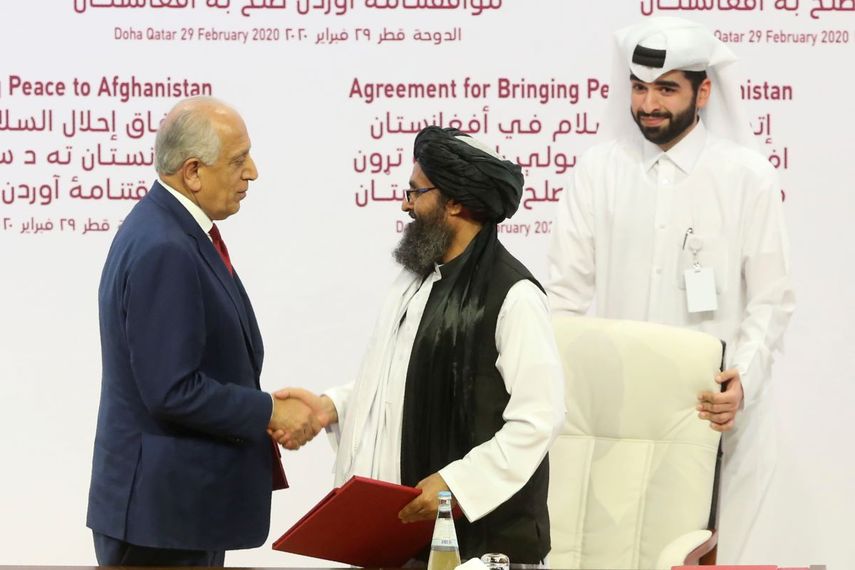 El enviado estadounidense Zalmay Khalilzad, izquierda, y el jefe político del Talibán, mulá Abdul Ghani Baradar, se estrechan la mano después de firmar el acuerdo de paz entre el Talibán y Estados Unidos en Doha, Qatar, sábado 29 de febrero de 2020