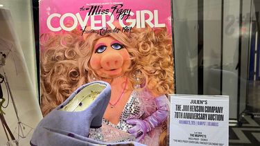 El calendario de fantasía de 1981 firmado por Miss Piggy, de la marca Cover Girl, se exhibe junto con un par de zapatos que ella usó durante la producción de la escena de la bicicleta ¿No podríamos montar? de Los Muppets en Aventuras. La exhibición se realizó durante una presentación previa a la subasta del 70 aniversario de la Jim Henson Company en el almacén de Juliens Auctions en Gardena, California, el 19 de noviembre de 2025.
