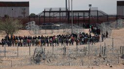 Migrantes hacen fila para ser trasladados por la Patrulla Fronteriza de Estados Unidos después de haber cruzado el río Bravo en El Paso, Texas, el 18 de abril de 2024.