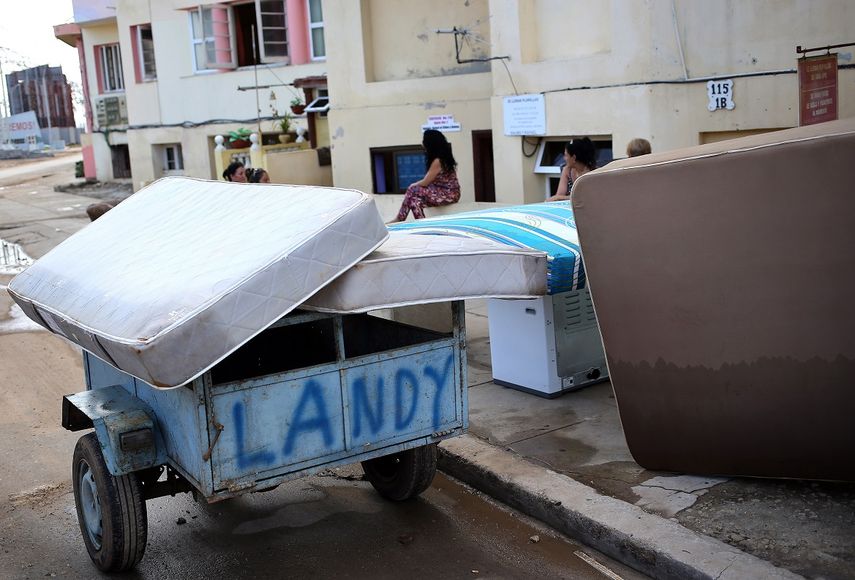 Personas secan sus pertenencias al sol en uno de los barrios afectados por el paso del huracán Irma, en La Habana.