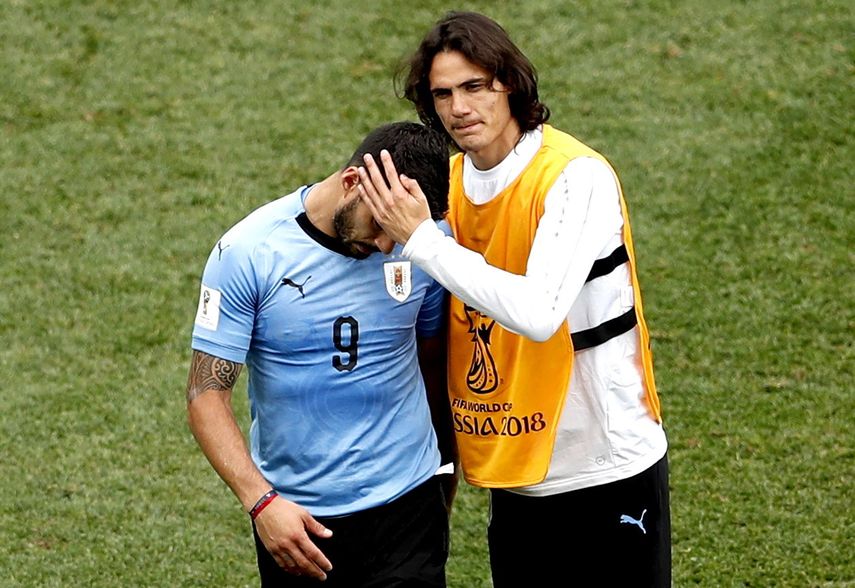 Edinson Cavani, quien no jugó por lesión, consolando a Luis Suárez tras el partido.