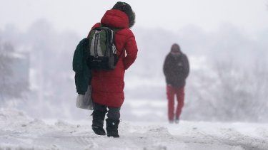 La gente camina sobre una calle nevada durante la tormenta invernal que azota a la región en Kansas City, Misuri, EE.UU., el martes 9 de enero del 2024.