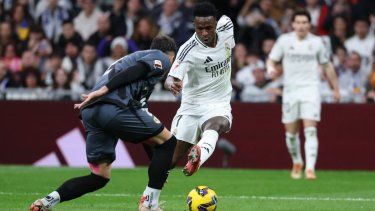 El brasileño Vinicius, del Real Madrid, encara al defensor del Rayo Vallecano, Andrei Ratiu, durante un partido entre ambos clubes, el 9 de marzo de 2025.