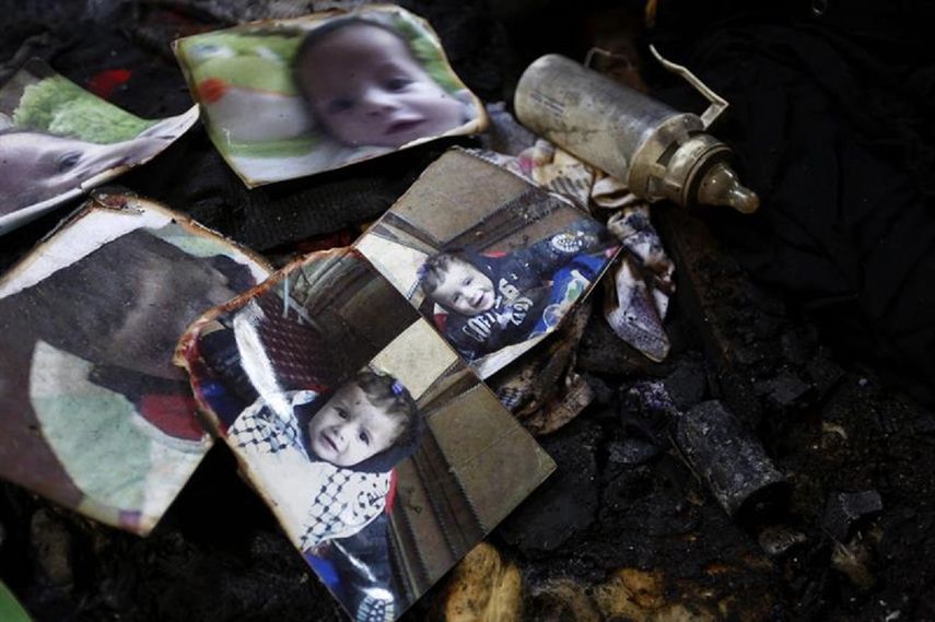 Un biberón descansa junto a las fotografías del bebé palestino de 18 meses, Ali Dawabsha. (EFE)