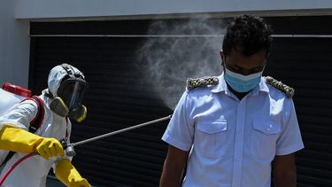 Un trabajador municipal que usa equipo de protección rocía desinfectante en un inspector de salud pública durante un bloqueo nacional impuesto por el gobierno como medida preventiva contra el coronavirus COVID-19 en Colombo el 31 de marzo de 2020. &nbsp; &nbsp;
