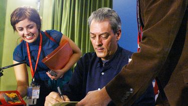 El escritor estadounidense Paul Auster (centro) da un autógrafo antes de una conferencia de prensa, el 18 de octubre de 2006, en la ciudad de Oviedo, en el norte de España, donde recibió el Premio Príncipe de Asturias de las Letras 2006.
