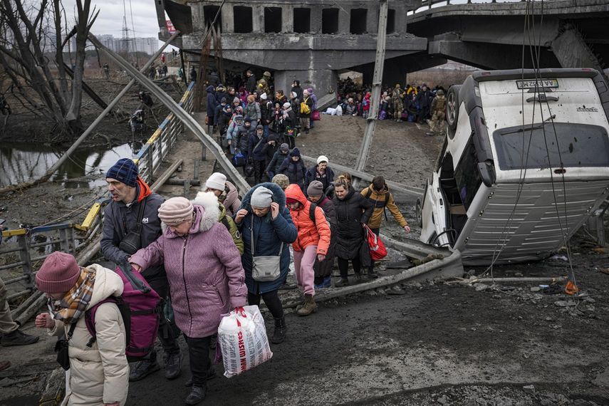 Las personas cruzan por un camino improvisado debajo de un puente que fue destruido por un ataque aéreo ruso, mientras huían de la ciudad de Irpin, Ucrania, el sábado 5 de marzo de 2022.&nbsp;