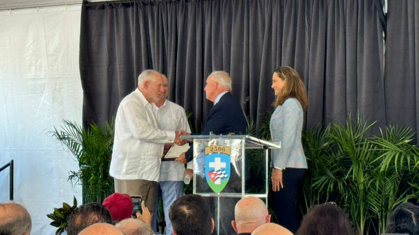 Los congresistas Carlos Giménez y María Elvira Salazar entregan una proclama al presidente de la Brigada 2506, Rafael Montalvo.