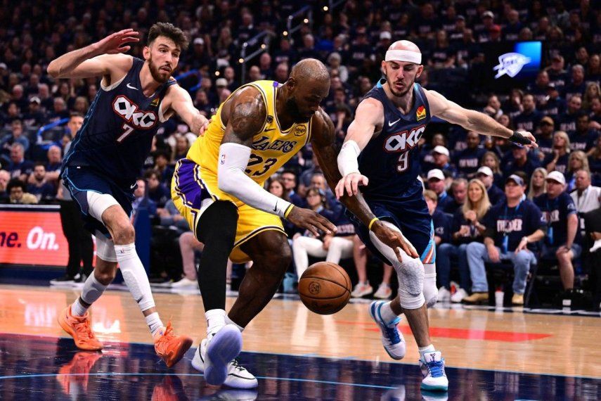 LeBron James #23 de Los Angeles Lakers lucha por el balón con Chet Holmgren #7 y Alex Caruso #9 de Oklahoma City Thunder&nbsp;