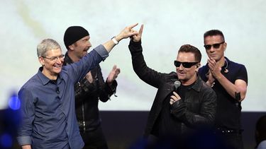 Tim Cook, presidente de Apple, saluda a Bono, de la banda U2, durante el cierre del evento de lanzamiento. (AP)