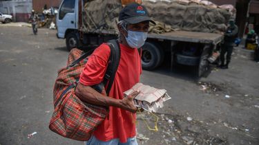 Un ciudadano&nbsp;en Venezuela carga huevos en su mano mientras usa mascarilla en los alrededores de un mercado municipal como medida preventiva contra el nuevo coronavirus, el 18 de marzo de 2020.