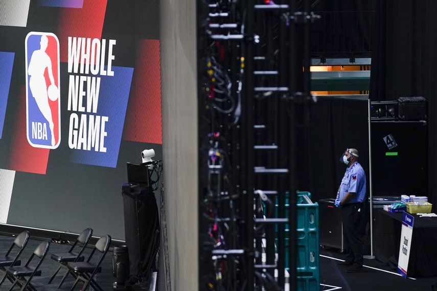 &nbsp;En esta foto del 29 de julio de 2020, un guardia de seguridad con mascarilla trabaja cerca de una arena dentro de la burbuja de ESPN en Lake Buena Vista, Florida