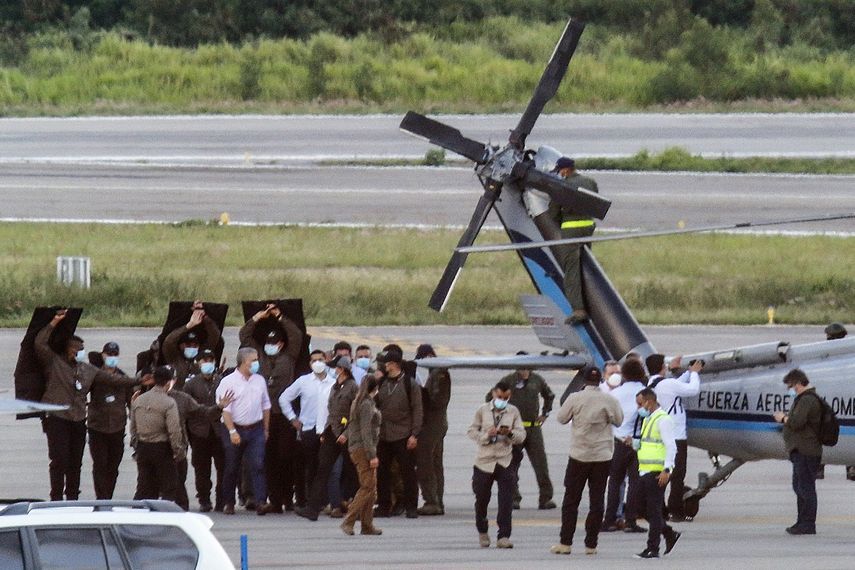 El presidente de Colombia, Iván Duque (izq.), Camina rodeado de guardaespaldas cerca del helicóptero presidencial en la pista del Aeropuerto Internacional Camilo Daza luego de que fuera alcanzado por disparos en Cúcuta, Colombia, el 25 de junio de 2021.&nbsp;&nbsp; &nbsp;