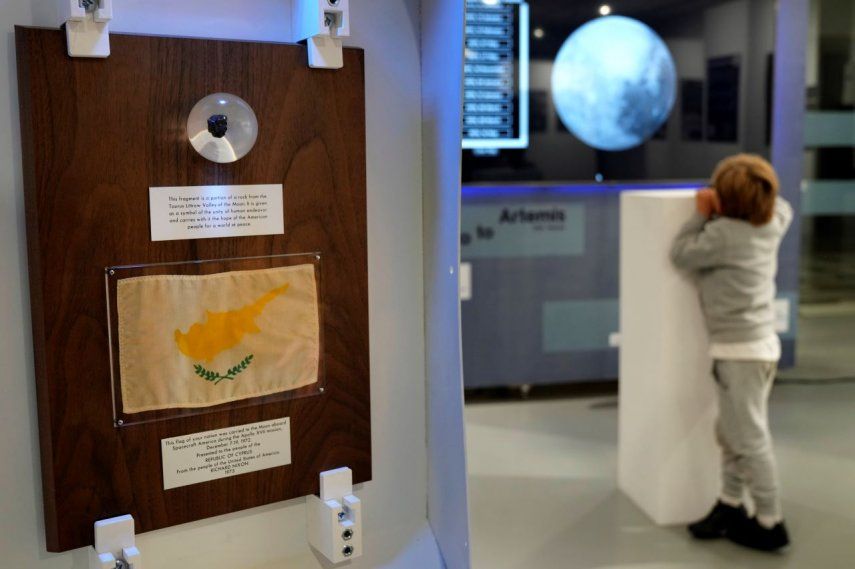 Un niño mira una pantalla que muestra la luna junto a un pequeño trozo de roca lunar dentro de un globo de plástico en una exposición que conmemora el 50 aniversario de la última de las misiones tripuladas de Estados Unidos a la luna y de la nave espacial Artemisa que ahora orbita alrededor de la luna, el jueves 8 de diciembre de 2022, en Nicosia, Chipre.&nbsp;