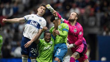 Stefan Frei, derecha, portero de Sounders de Seattle, despeja con el puño el balón ante el intento de remate de Brian White, izquierda, de Whitecaps de Vancouver, durante la primera mitad del juego de la MLS el domingo 7 de noviembre de 2021, en Vancouver