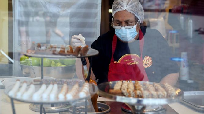 Una señora trabaja en una dulcería.