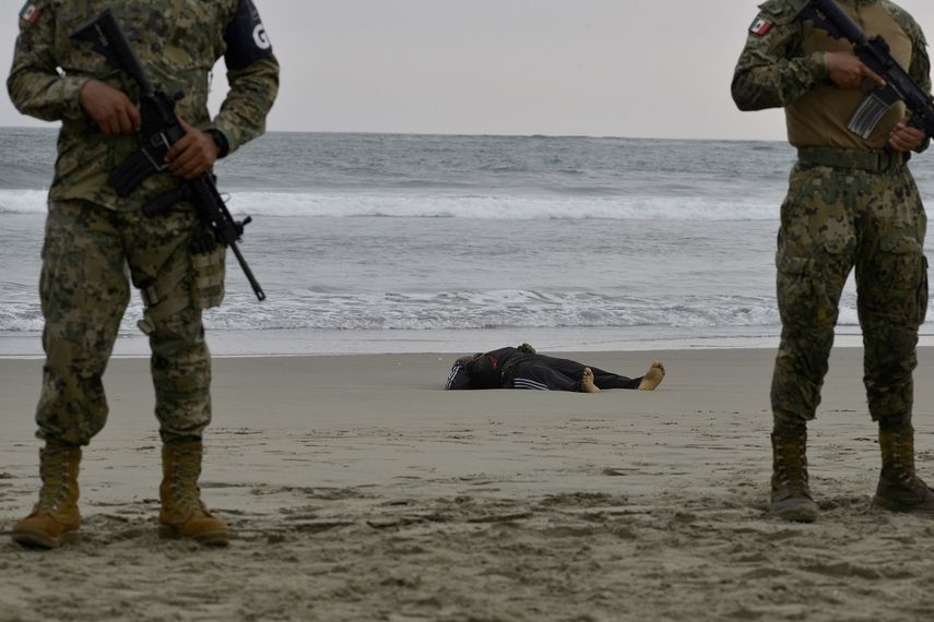 Fuerzas de seguridad forman un per&iacute;metro alrededor del cadaver de Emmanuel Cheo Ngu, de Camer&uacute;n, en la orilla de la playa Boca Barra, en Puerto Arista, M&eacute;xico, el viernes 11 de octubre de 2019.