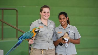 Trabajadoras del parque Jungle Island dan la bienvenida con dos de las especies autóctonas que muestran durante el Mes de la Hispanidad.