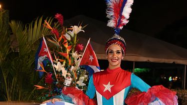Una joven viste un traje que recuerda a la bandera de Cuba.