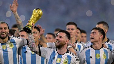 Lionel Messi (centro) levanta una réplica del trofeo de la Copa del Mundo frente a sus compañeros en una ceremonia.