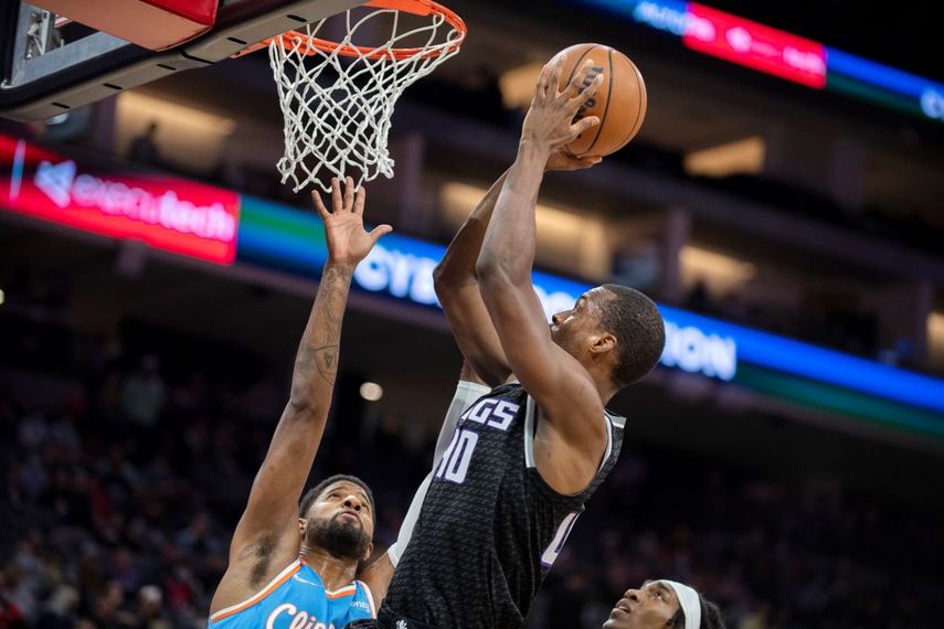 Harrison Barnes (40), de los Kings de Sacramento, encesta ante el jugador de los Clippers de Los Ángeles Paul George, a la izquierda en el primer cuarto de su juego de NBA en Sacramento, California, el miércoles 22 de diciembre de 2021.