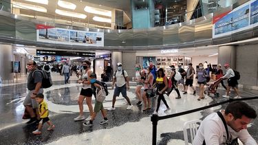 Viajeros transitan por uno de los extensos corredores del Aeropuerto Internacional de Miami (MIA).