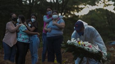 Familiares de una víctima de la enfermedad del nuevo coronavirus COVID-19 lloran mientras su ser querido es enterrado en el cementerio de Vila Formosa en Sao Paulo, Brasil, el 31 de marzo de 2021. 