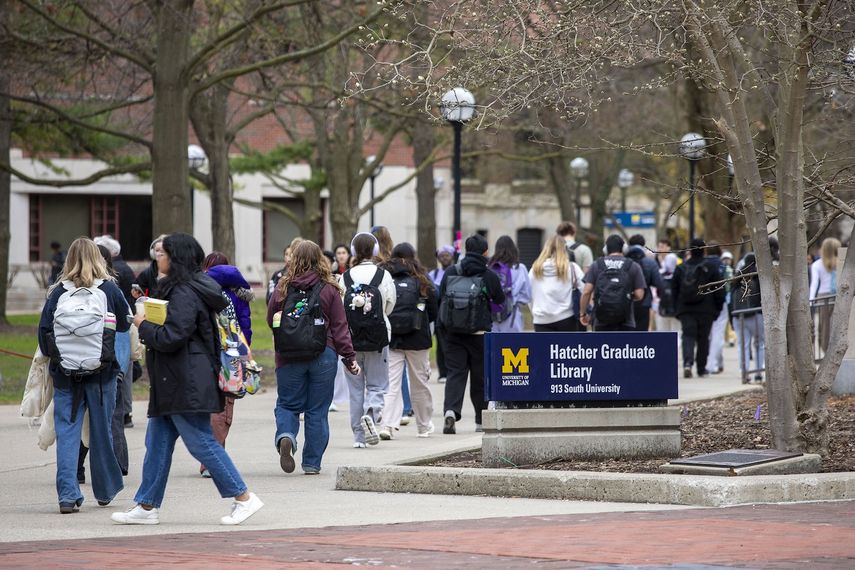 Estudiantes de la Universidad de Michigan, en Ann Arbor, caminan por el campus de la UM en abril de 2025.