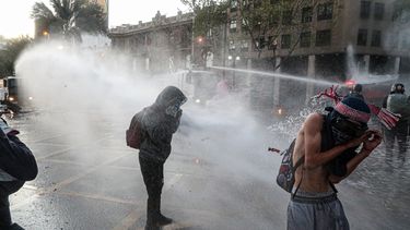 Manifestantes antigubernamentales son reprimidos con ca&ntilde;ones de agua de la polic&iacute;a durante una protesta en Santiago de Chile, el viernes 9 de octubre de 2020.&nbsp;