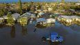 Casas y vehículos rodeados de una inundación tras varios días de lluvias en la población Planada del condado Merced, California, el martes 10 de enero de 2023.