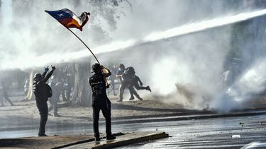 Los manifestantes son rociados por un cañón de agua de la policía antidisturbios durante una protesta contra el gobierno del presidente de Chile, Sebastián Piñera, en Santiago el 30 de octubre de 2020. Los ciudadanos del país sudamericano votaron por un deslizamiento de tierra en un referéndum el domingo para desechar su constitución de la era de la dictadura, acusados por las discordantes desigualdades económicas y sociales que llevaron a meses de violentas protestas.