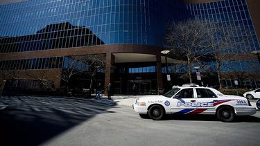 Patrullas de la policía aparcadas frente a un edificio de oficinas luego de que un hombre apuñalara a cuatro colegas en Toronto, el miércoles 9 de abril de 2014. (Foto AP)