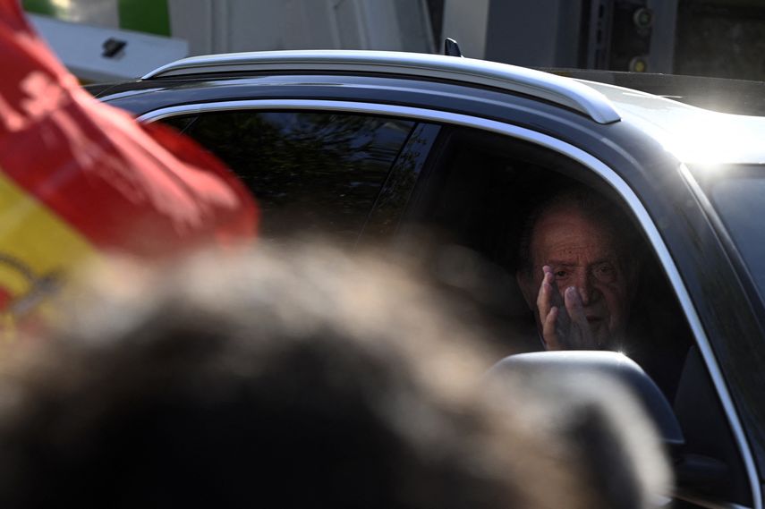 El rey emérito Juan Carlos I de España saluda desde un automóvil cuando llega al palacio de La Zarzuela, en Madrid, el 23 de mayo de 2022 para reunirse con su hijo, el rey Felipe VI de España.